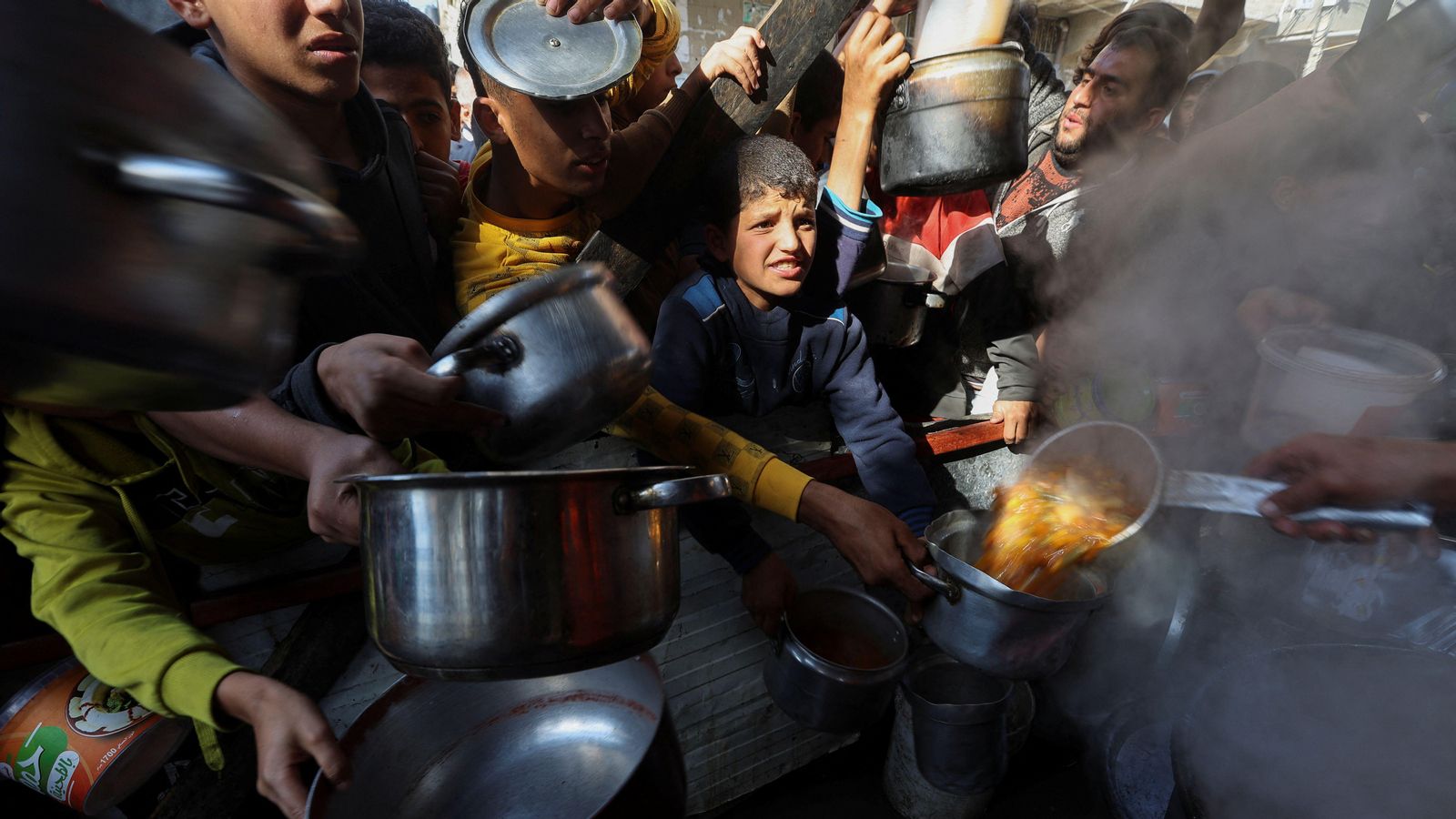 Un grup de palestins rep a Rafah (sud de la Franja de Gaza) la ració diària d'aliments proporcinada per voluntaris