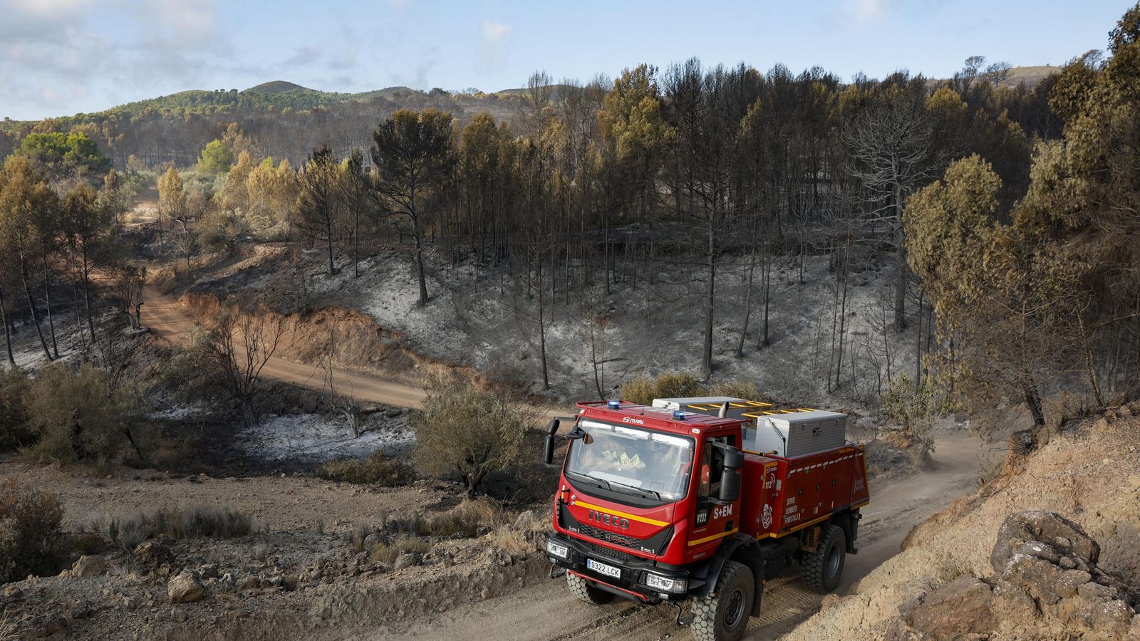 Un vehicle del Servei de Bombers Forestals de la Generalitat recorre una de les zones afectades per les flames