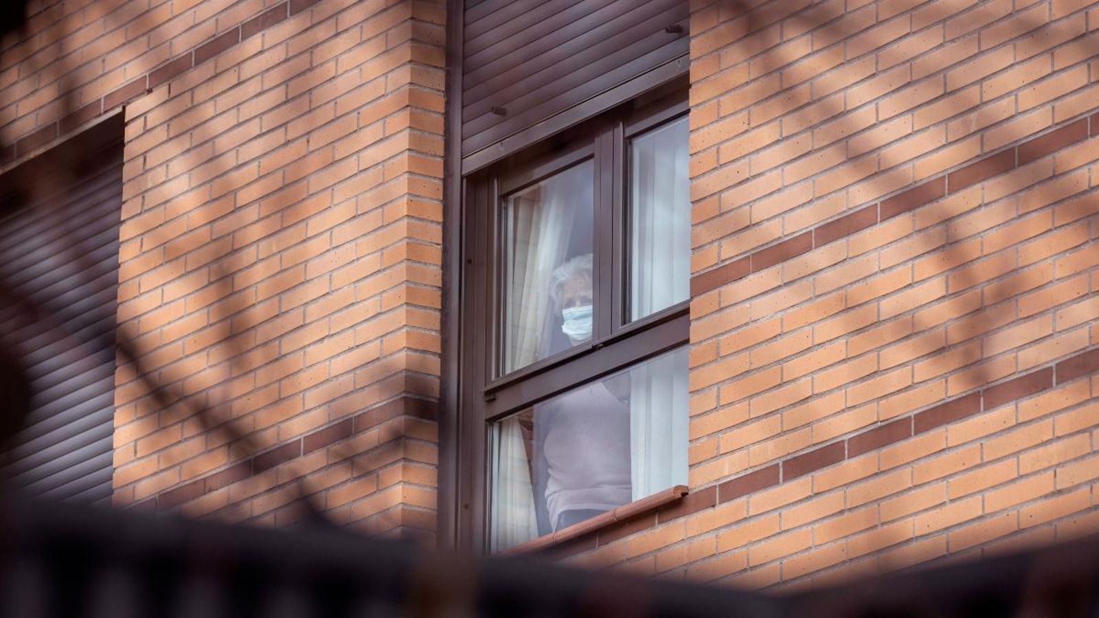 Una resident darrere de la finestra del centre on viu, en una imatge de fa uns dies