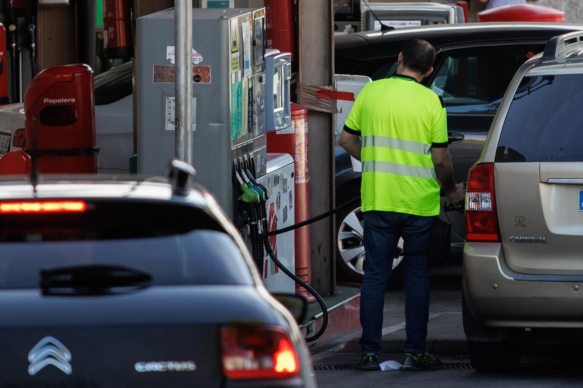 Un operari ompli un vehicle en una gasolinera