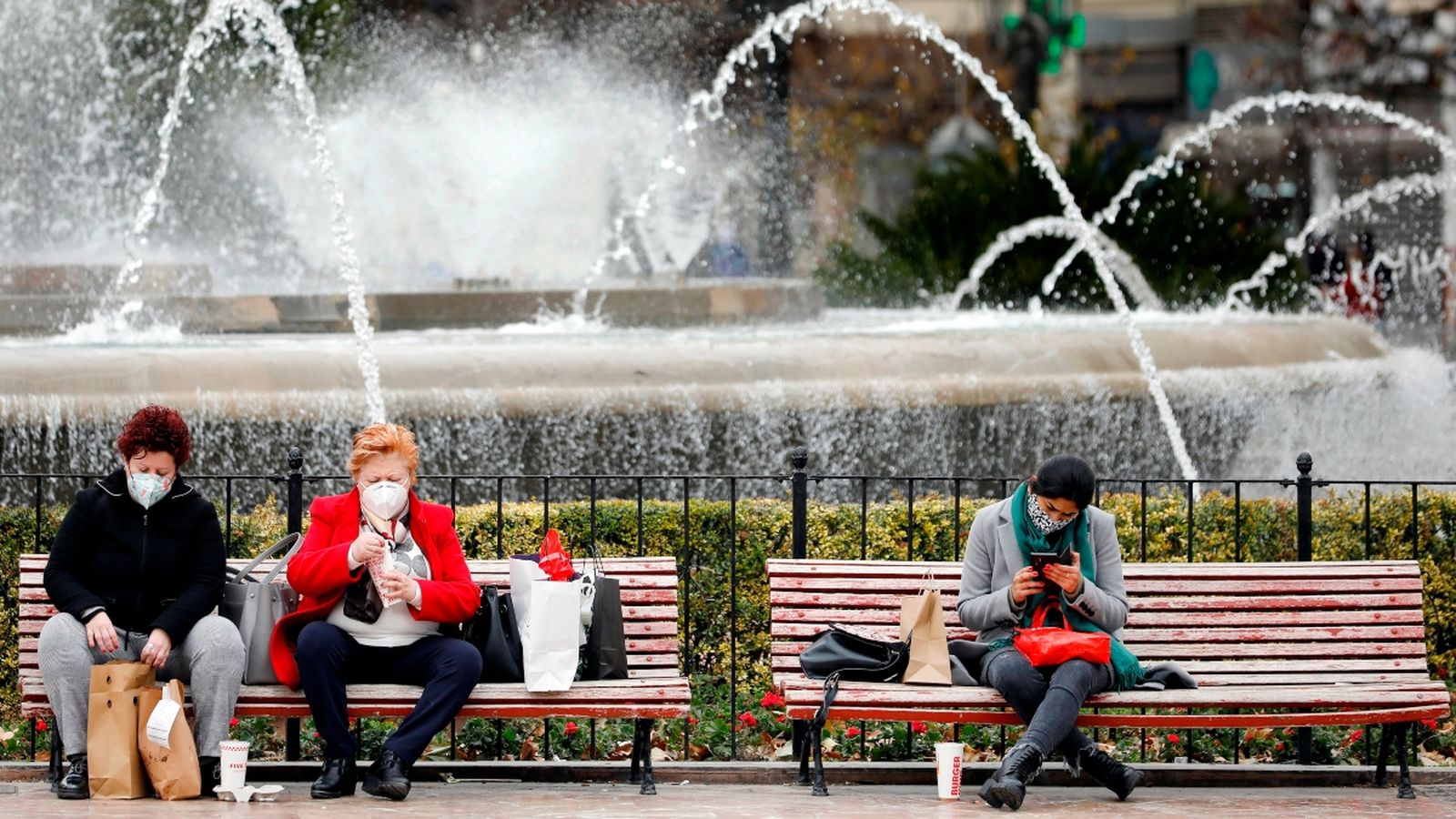 Tres dones segudes en alguns dels bancs de la Plaça de l'Ajuntament de València