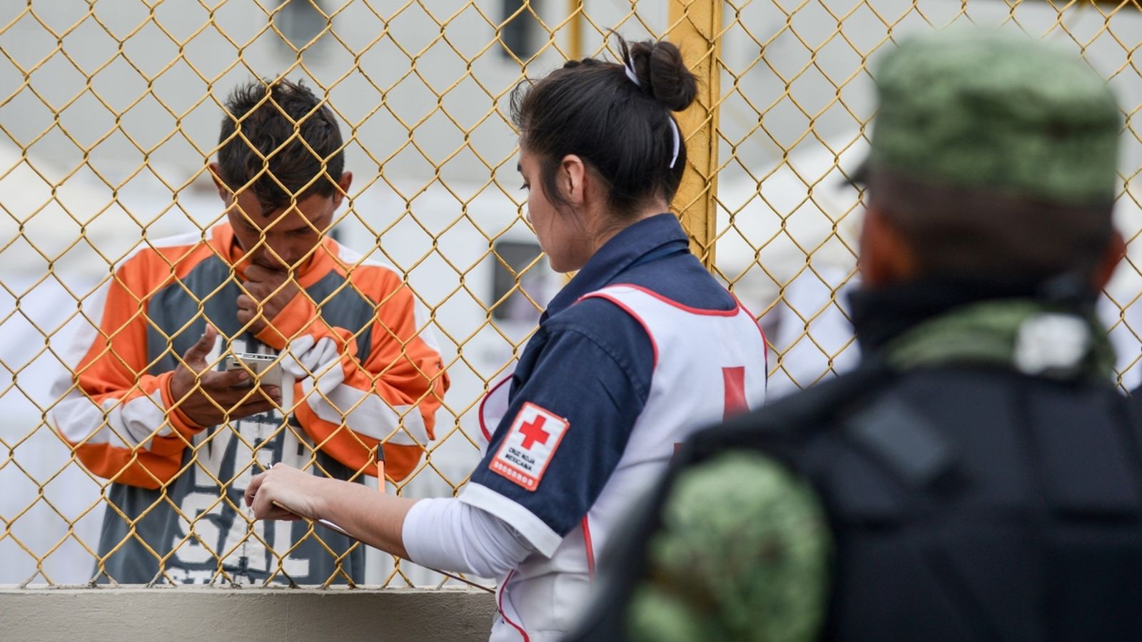 Una socorrista de la Creu Roja conversa amb un migrant d'Amèrica Central, aquest dilluns aPiedras Negras (Mèxic)
