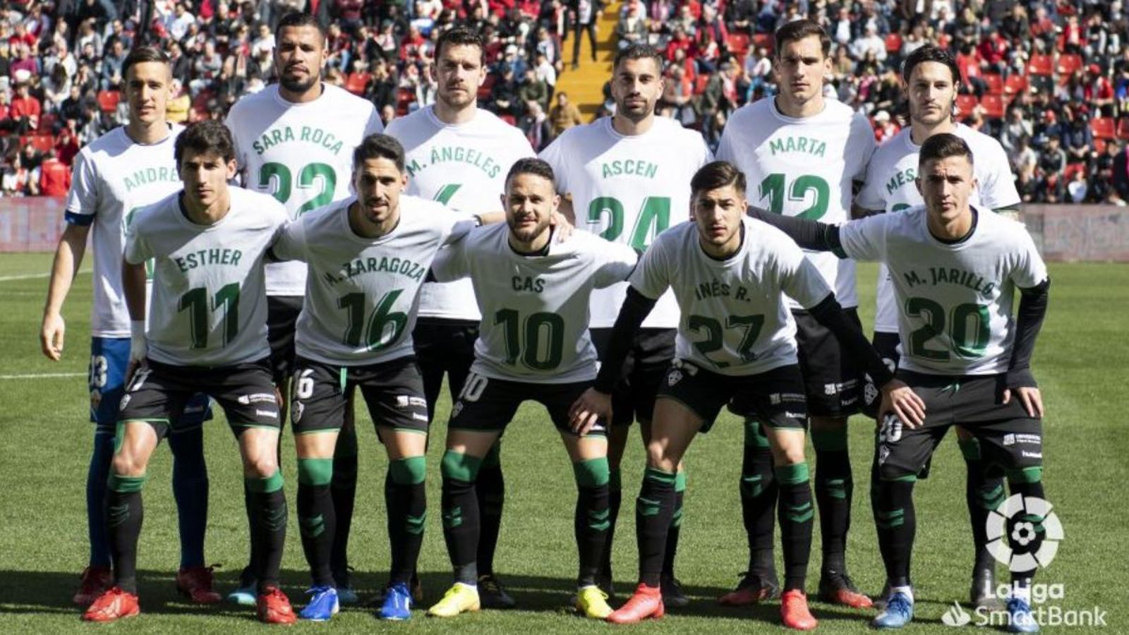 Els futbolistes de l’Elx posen amb samarretes de l’equip femení franjaverd