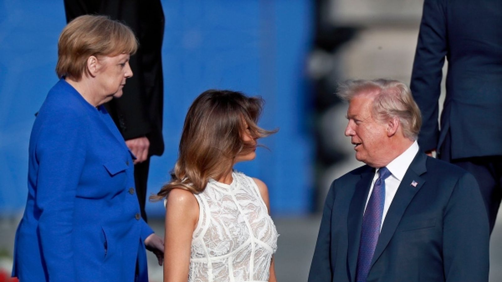 Trump (dreta) parla amb la primera dama (centre) front la canciller alemanya, Angela Merkel (esquerra).