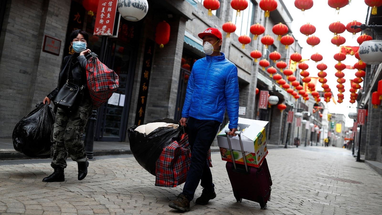 Dos joves caminen amb mascaretes protectores per un barri històric de Pequín, que habitualment es troba ple de turistes, el passat 26 de març
