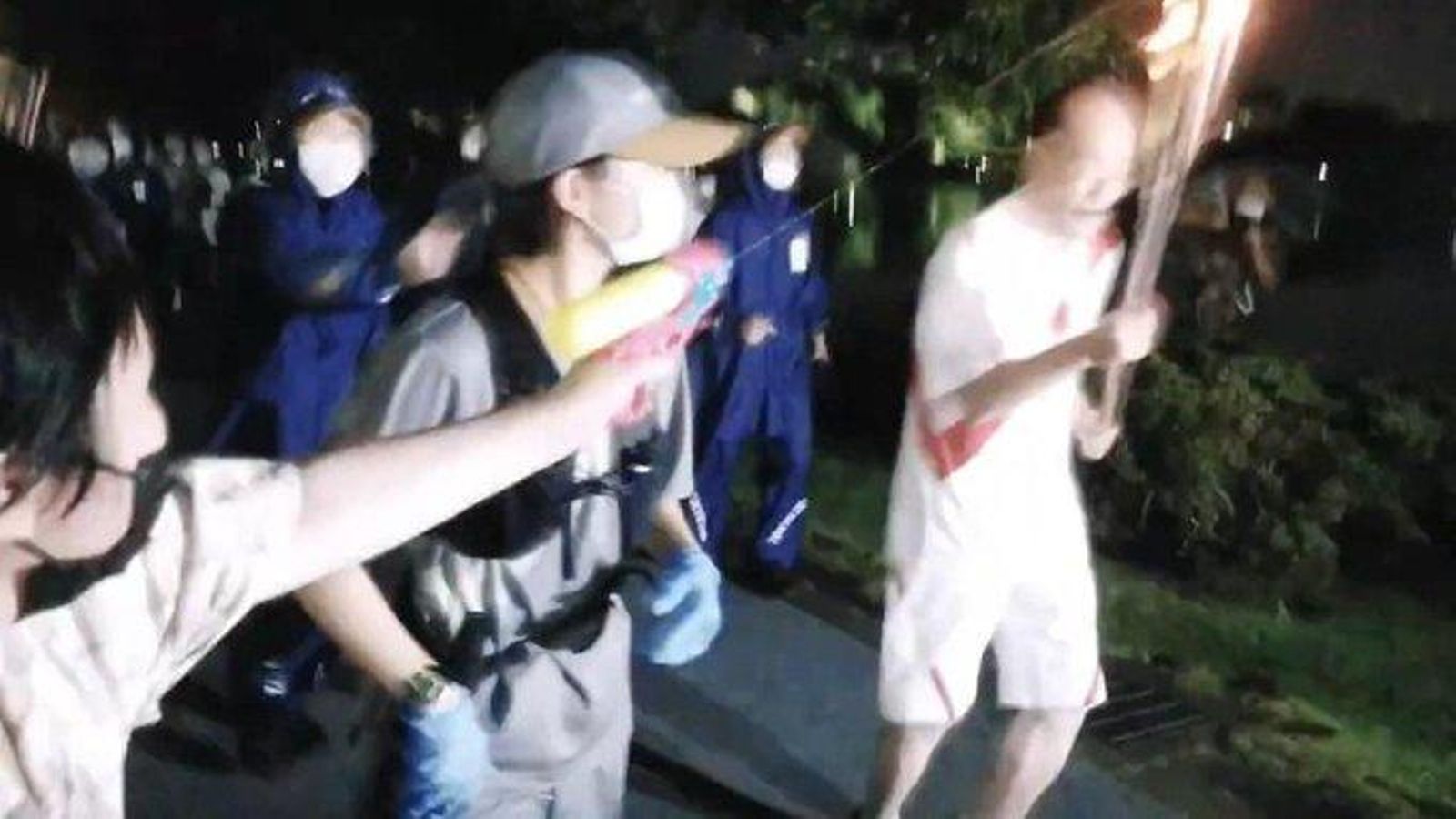 Moment en què una dona llança aigua a la flama olímpica