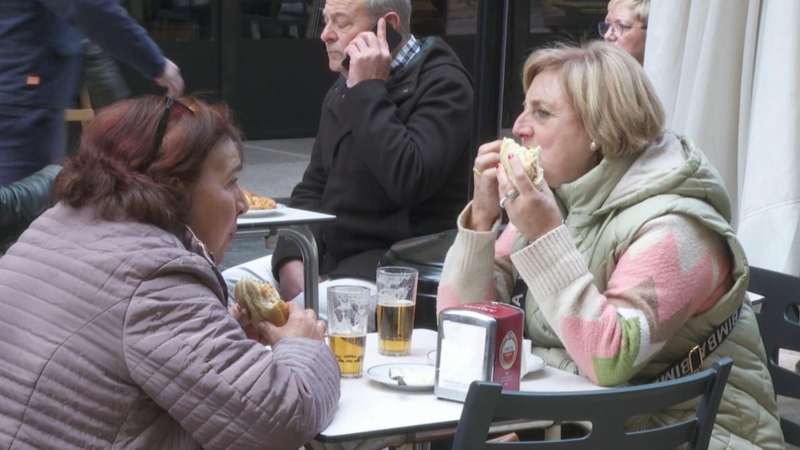 Dues turistes esmorzen en un bar de València durant les Falles
