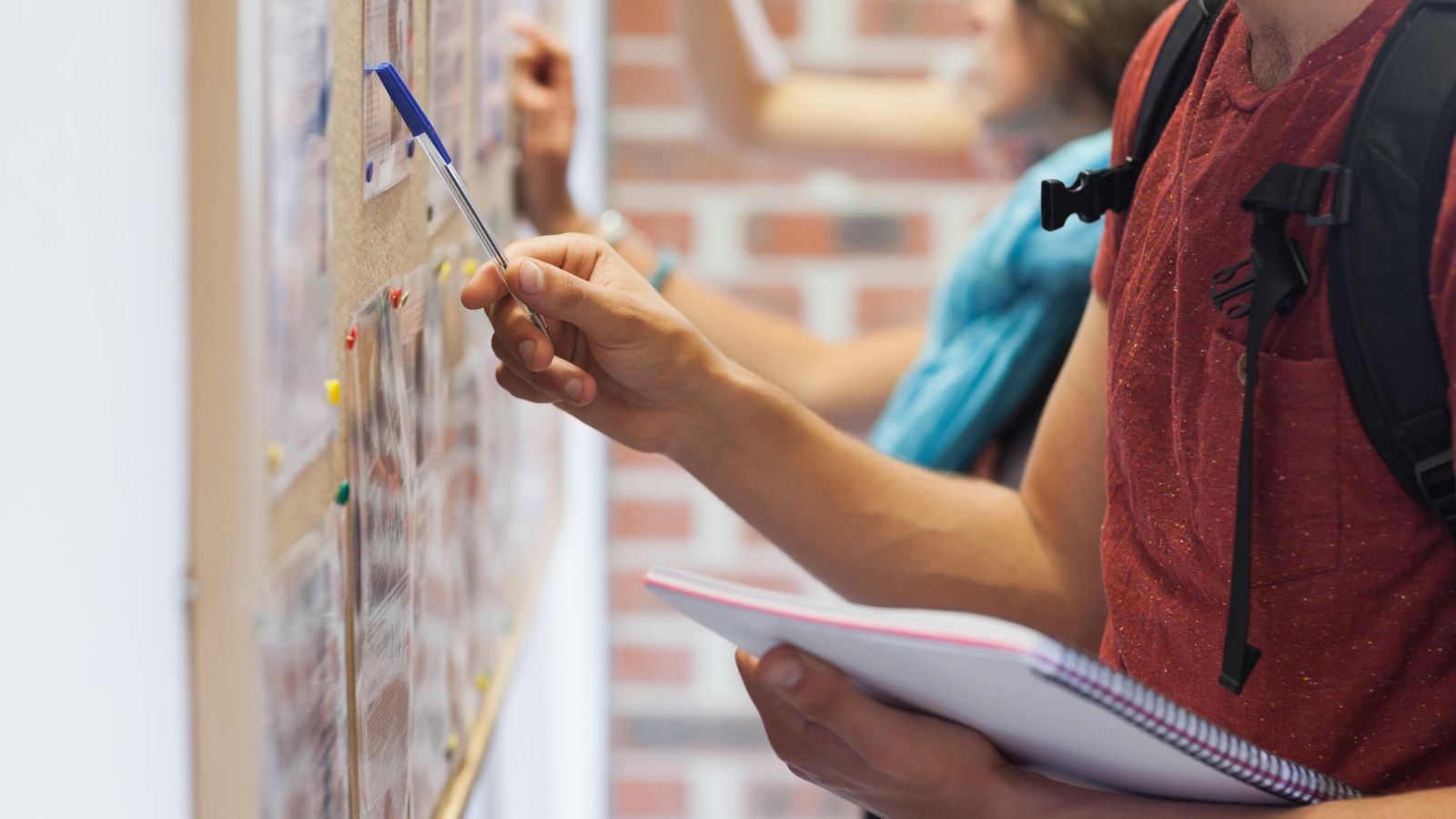 L'estudiantat consulta la informació d'un tauler a la universitat