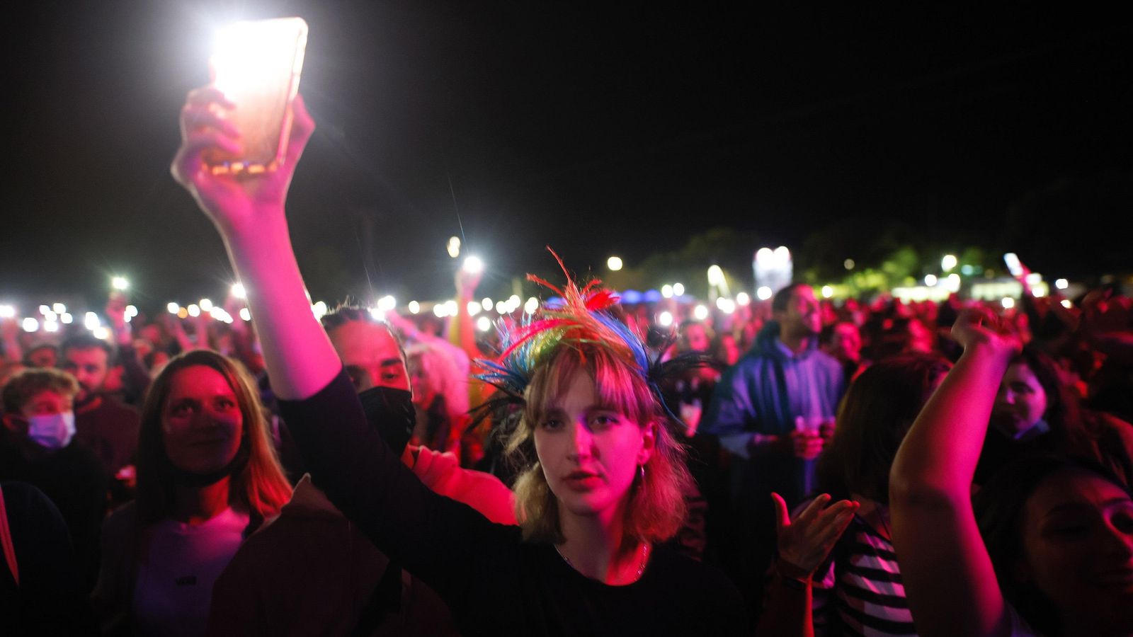 Una xica il·lumina l'escenari amb el mòbil, durant un concert en el festival SanSan 2021 de Benicàssim Una xica il·lumina amb el seu mòbil l'escenari durant un concert al festival Sansan de Benicàssim 2021