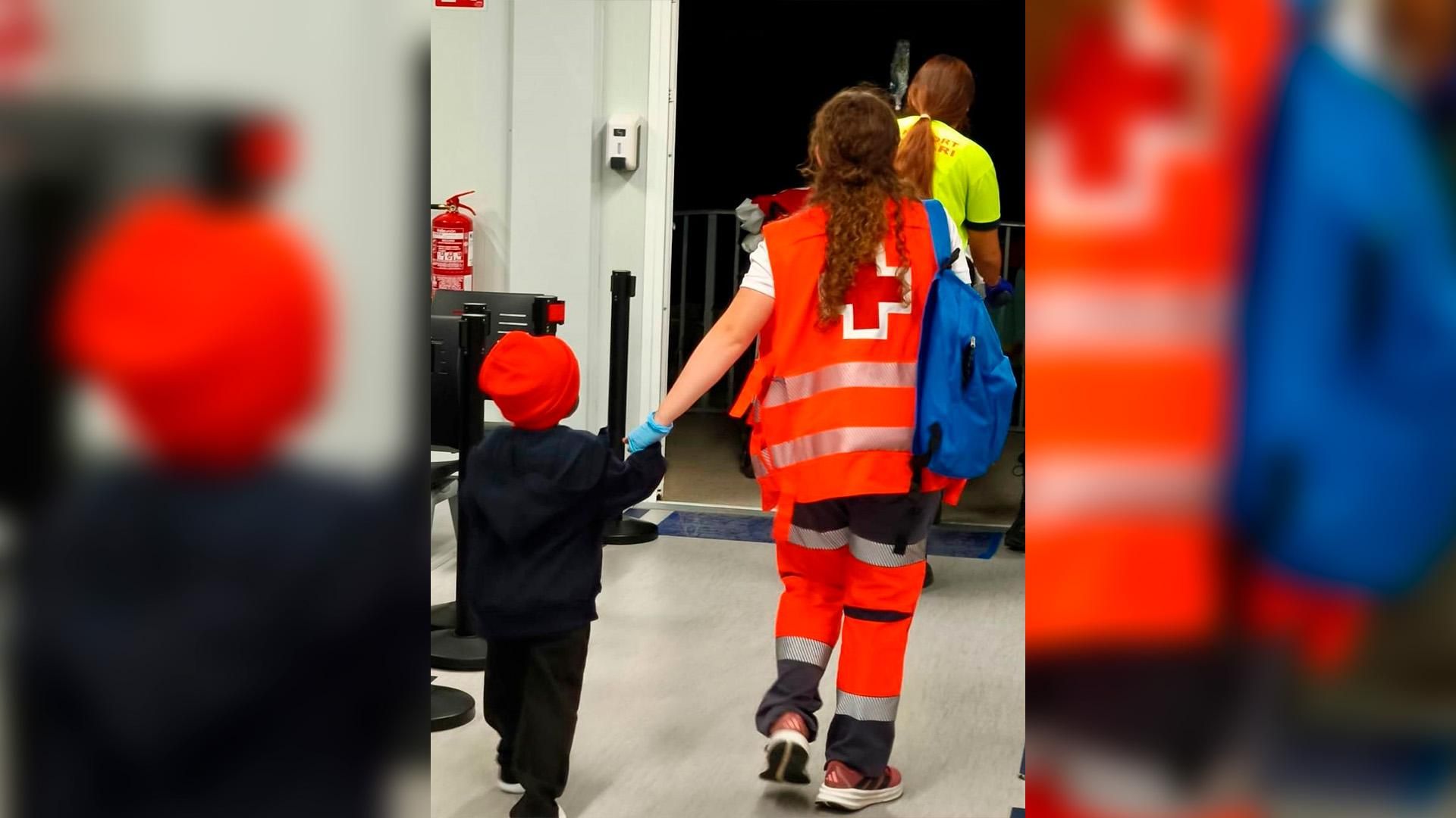 Voluntària de la Creu Roja amb un dels menors rescatats Migrants Alacant