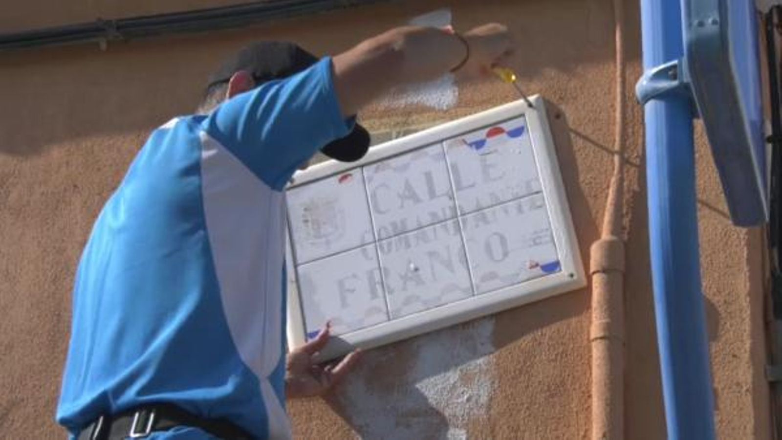 Un operari retira la placa del carrer del Comandant Franco al barri de Sant Gabriel