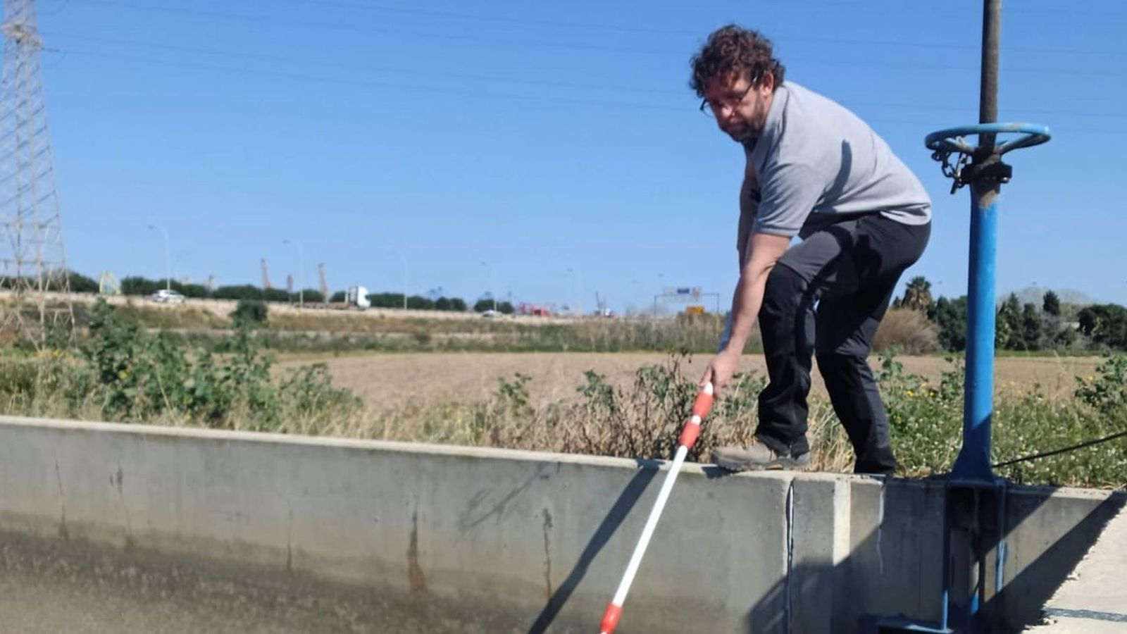 Un operari agarra mostres en una séquia, en una imatge d'arxiu