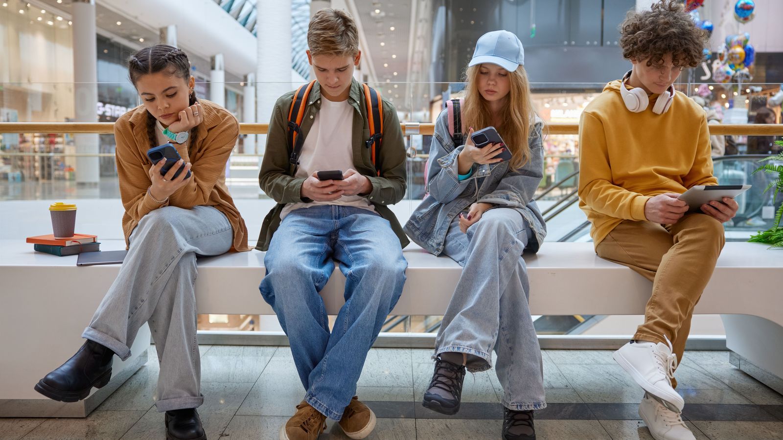 Un grup d'adolescents utilitzen els seus mòbils en un centre comercial