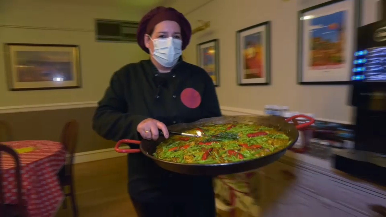 Alicia a punt de servir una paella al seu restaurant