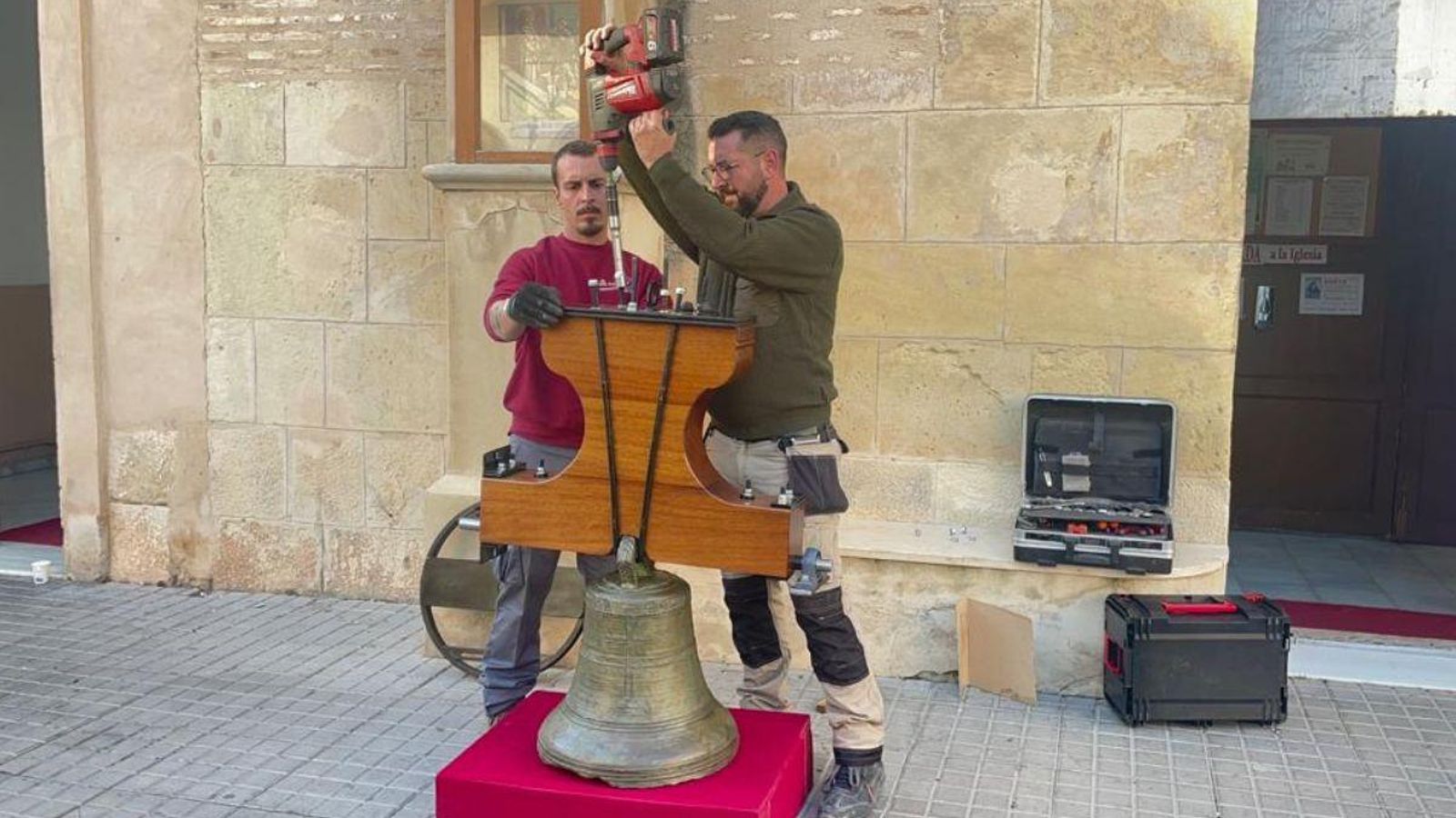 Els operaris treballen a ajustar la campana abans de tornar a pujar-la al campanar Els operaris treballen en ajustar la campana abans de tornar a pujar-la a la façana del campanari