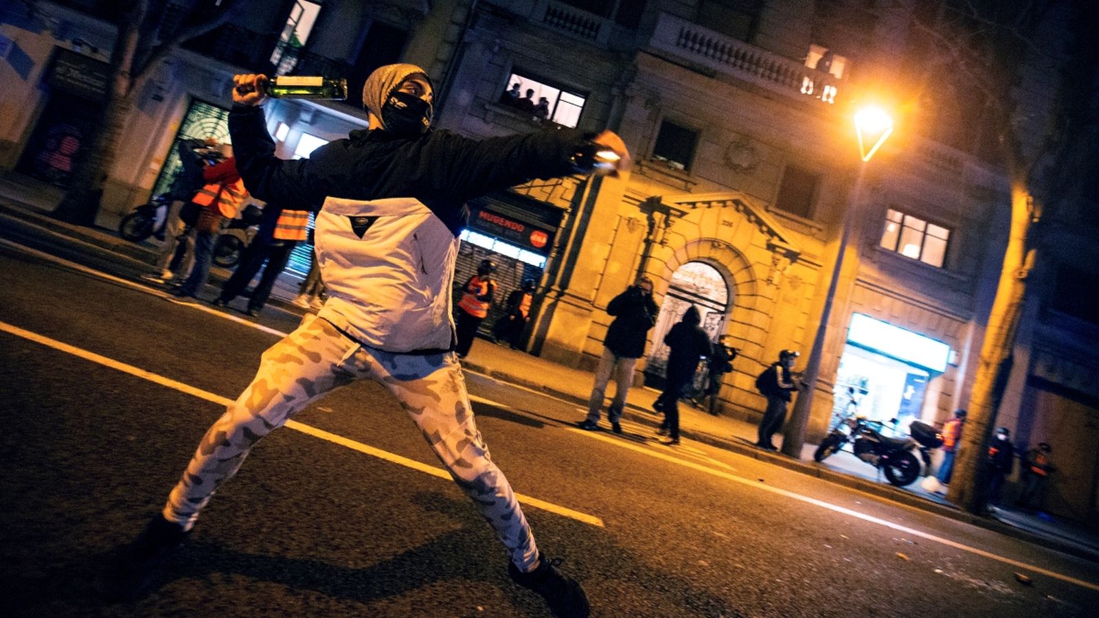 Un manifestant llança una botella a la policia durant la protesta contra la detenció de Pablo Hasel