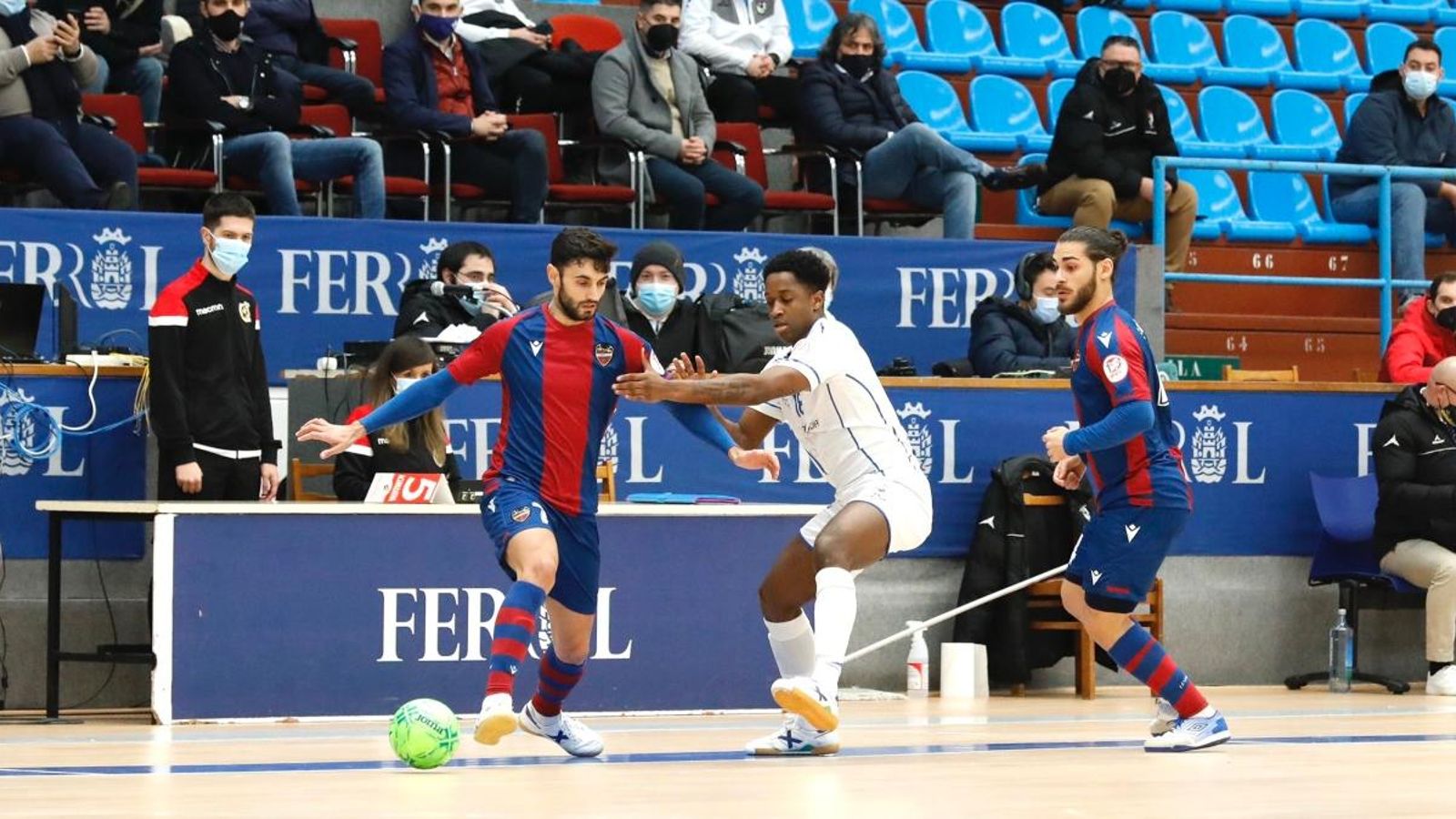 Un jugador del Llevant manté la pilota davant de la pressió d'un jugador de l'O Parrulo