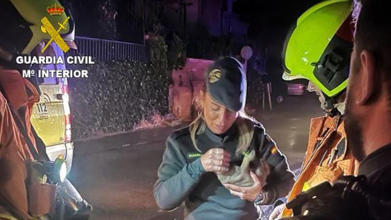 Una agent de la Guàrdia Civil sosté un dels cadells de gos salvats de l'incendi