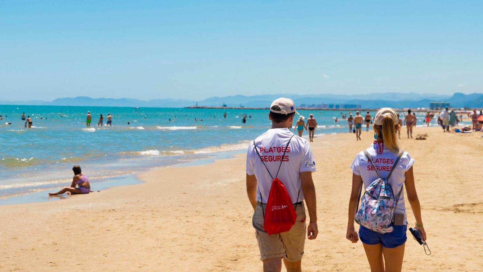 Dos informadors passegen per una de les platges de Cullera