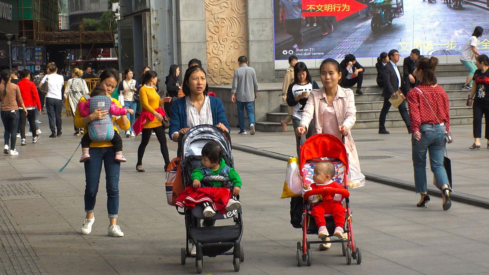 Dues dones passegen amb els seus nadons per una ciutat xinesa