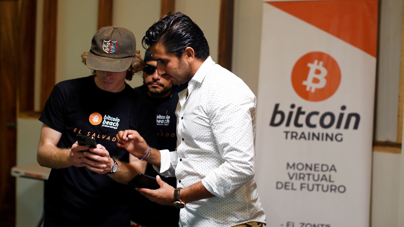 Un sseguidor de Bitcoin conversa amb el cofundador de Bitcoin Beach, Roman Martinez, en la seua seu a Chiltiupán, El Salvador
