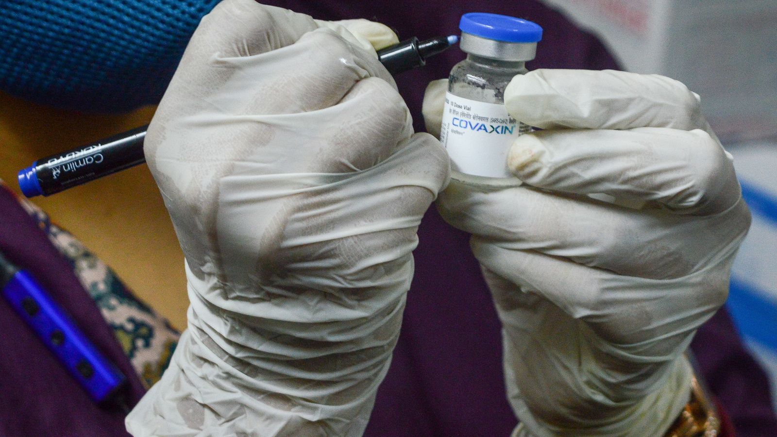 Una treballadora sanitària marca la data a un vial de Covaxin, la vacuna índia