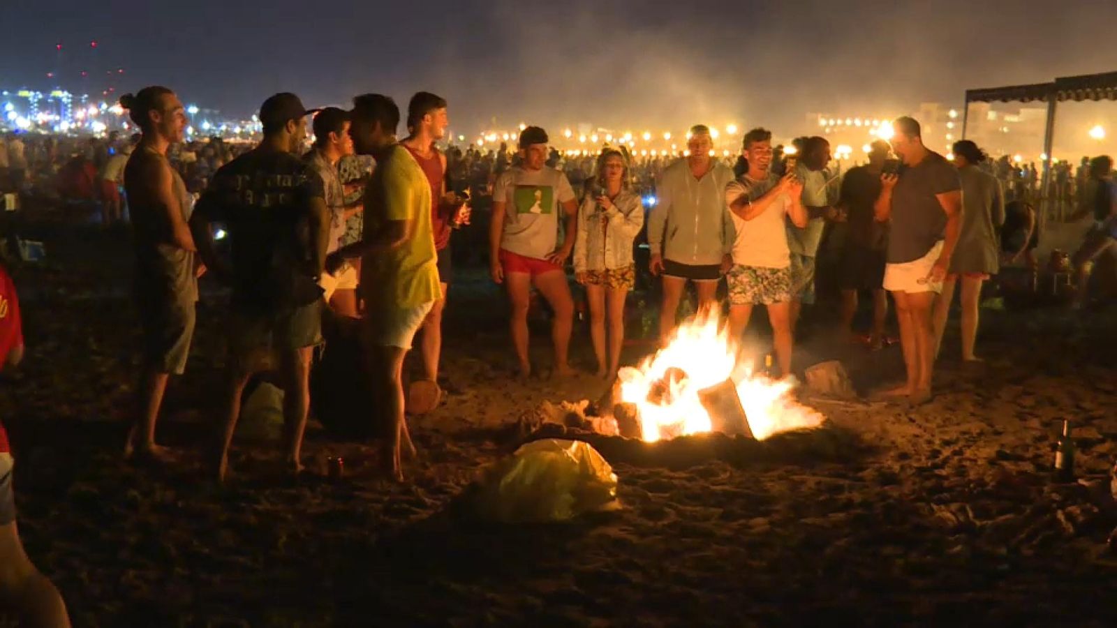 Un grup de joves al voltant d'una foguera a la platja de les Arenes, a València, la Nit de Sant Joan de 2019