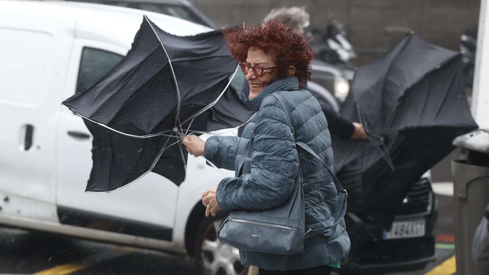 Una dona s'enfronta a les fortes ratxes de vent del temporal Ciarán mentre camina per un carrer de Madrid
