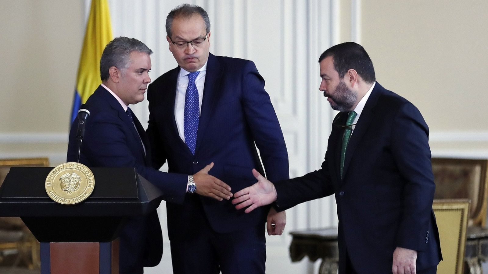 El defensor del poble Carlos Alfonso Negret (dreta) dona la mà al president Iván Duque (esquerra) aquest dilluns a Bogotà