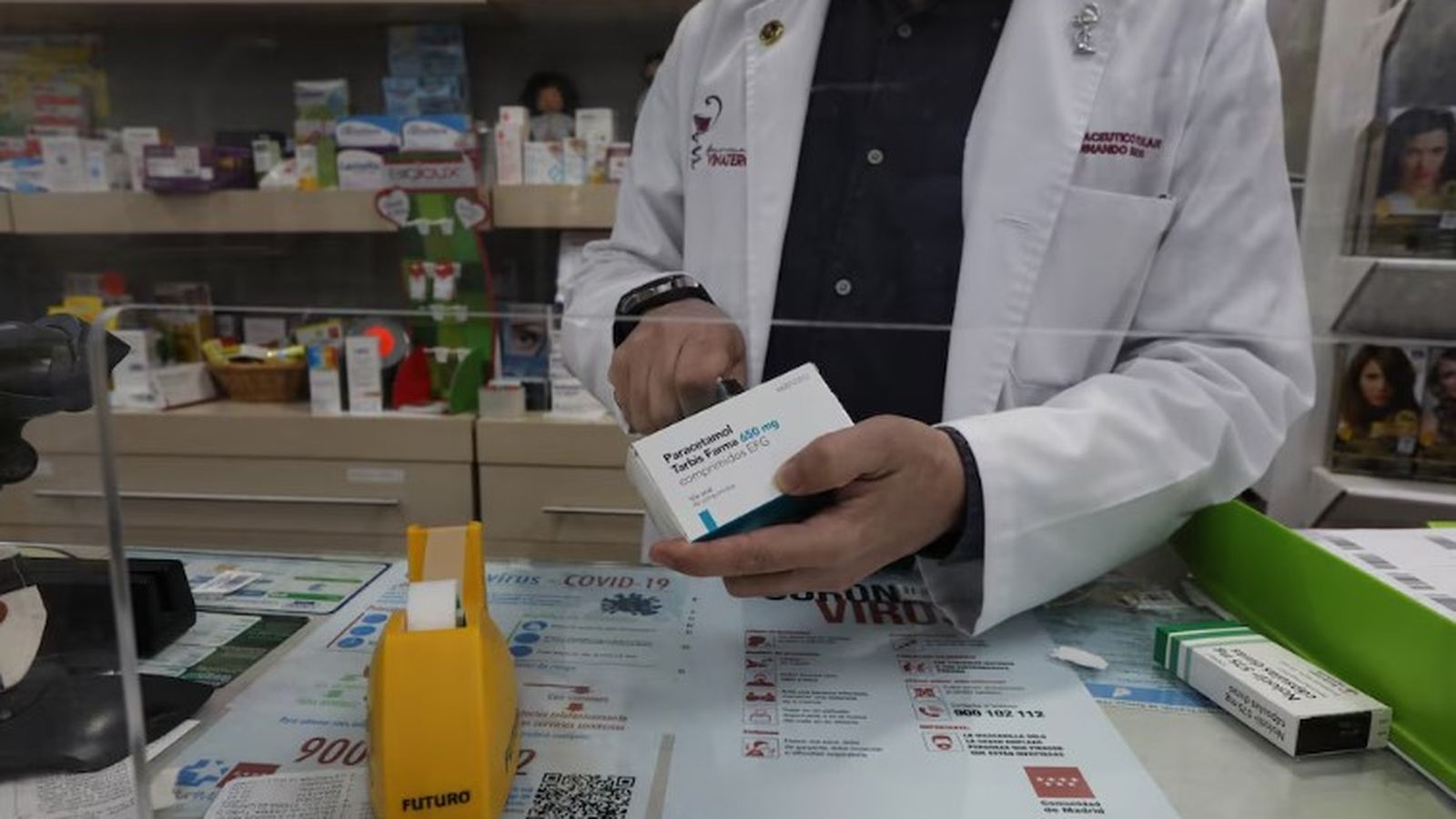 Un farmacèutic retalla el codi de barres d'una caixa de Paracetamol