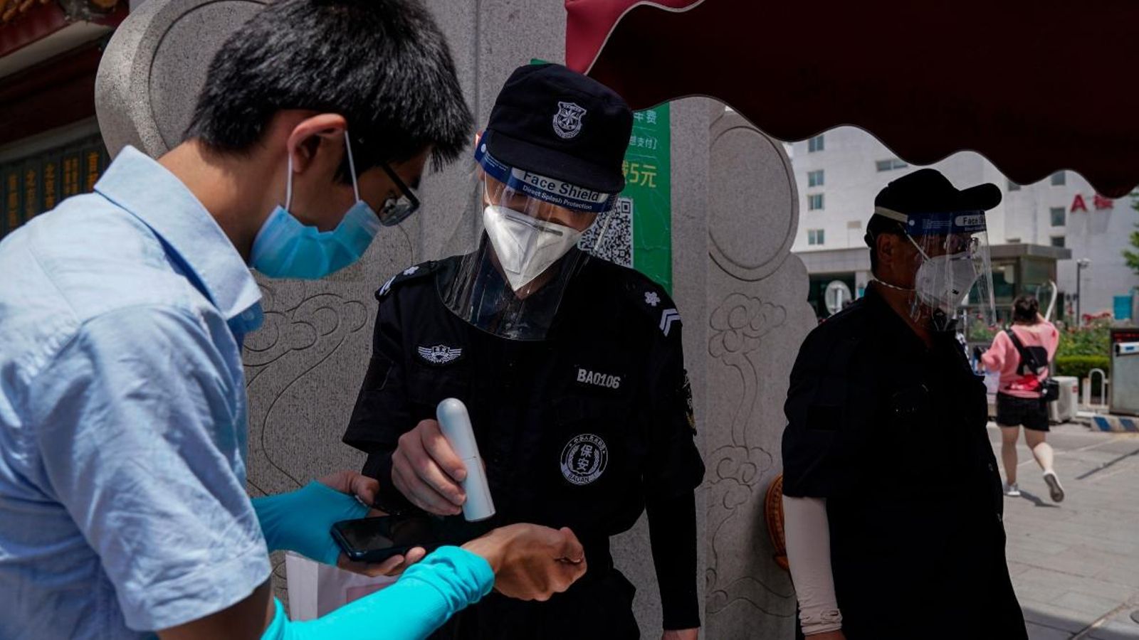 Un vigilant de seguretat comprova la temperatura de la gent a l’entrada de l’hospital Youan per fer proves COVID-19 a Pequín