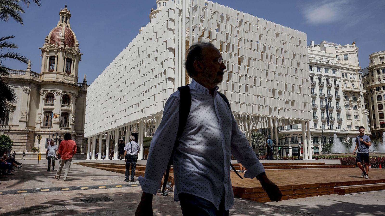 Una persona camina davant l'Àgora de València, a la plaça de l'Ajuntament