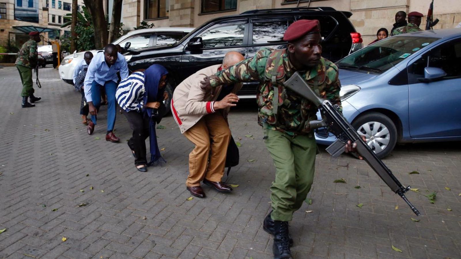 Un membre de les forces de seguretat evacua un grup de ciutadans de la zona on s'han produït els atacs. Baz Ratner (Reuters).