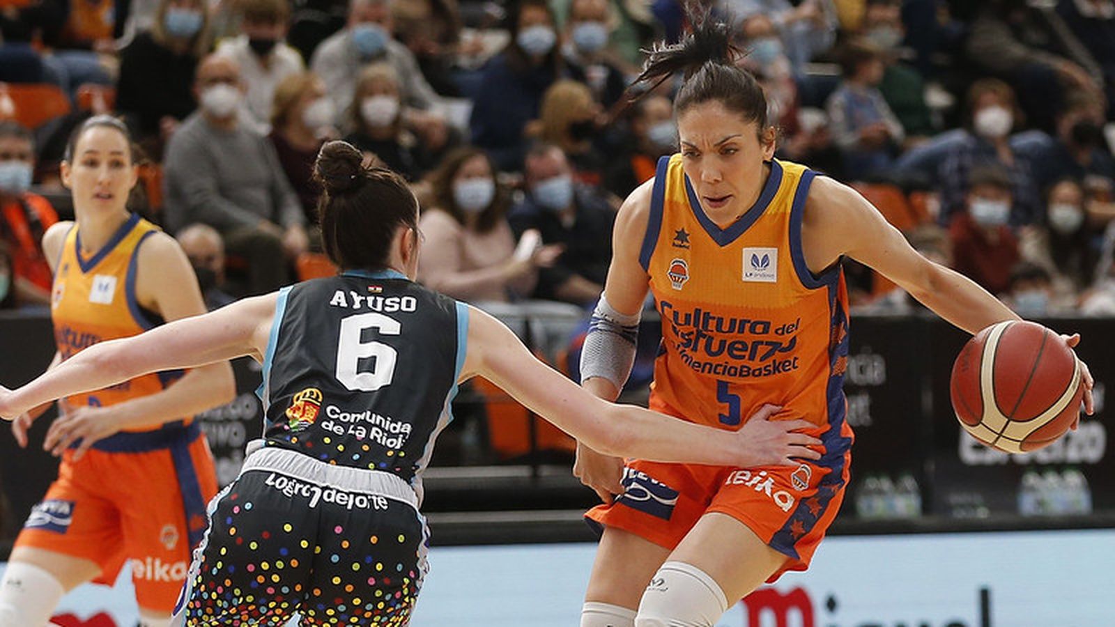 Cristina Ouviña condueix un baló davant la defensa d'una jugadora del Campus Promete