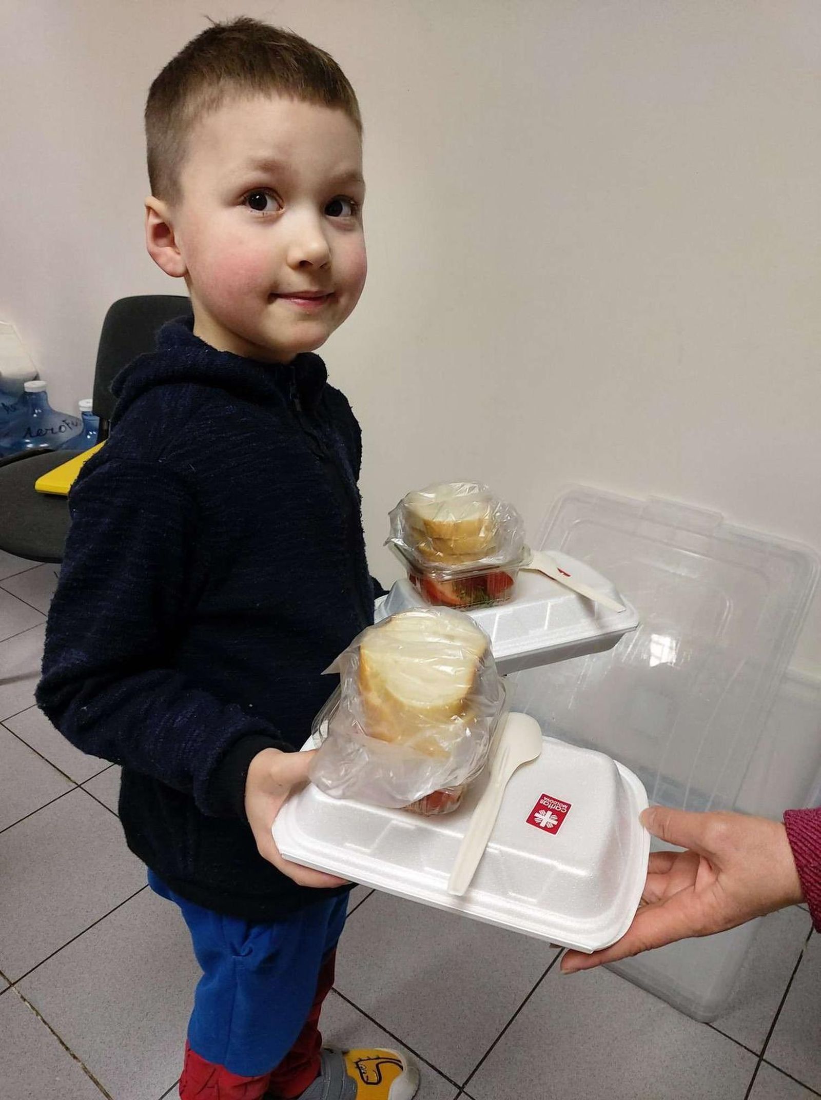 Un xiquet ucraïnés rep menjar de l'ONG WCK a la frontera amb Moldàvia