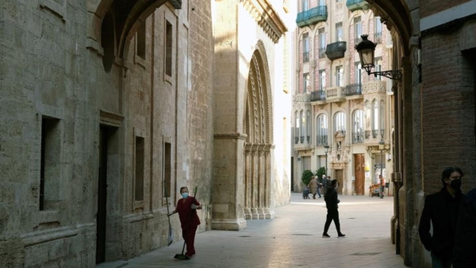 Personal de neteja amb mascaretes al voltant de la catedral de València