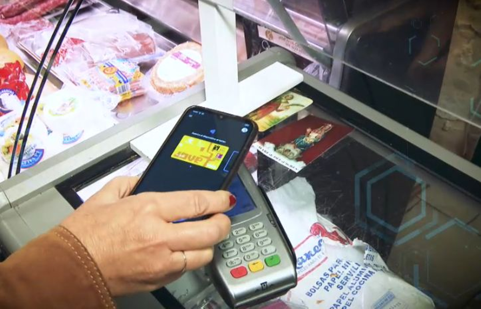 Una dona paga a la carnisseria amb el mòbil.PNG