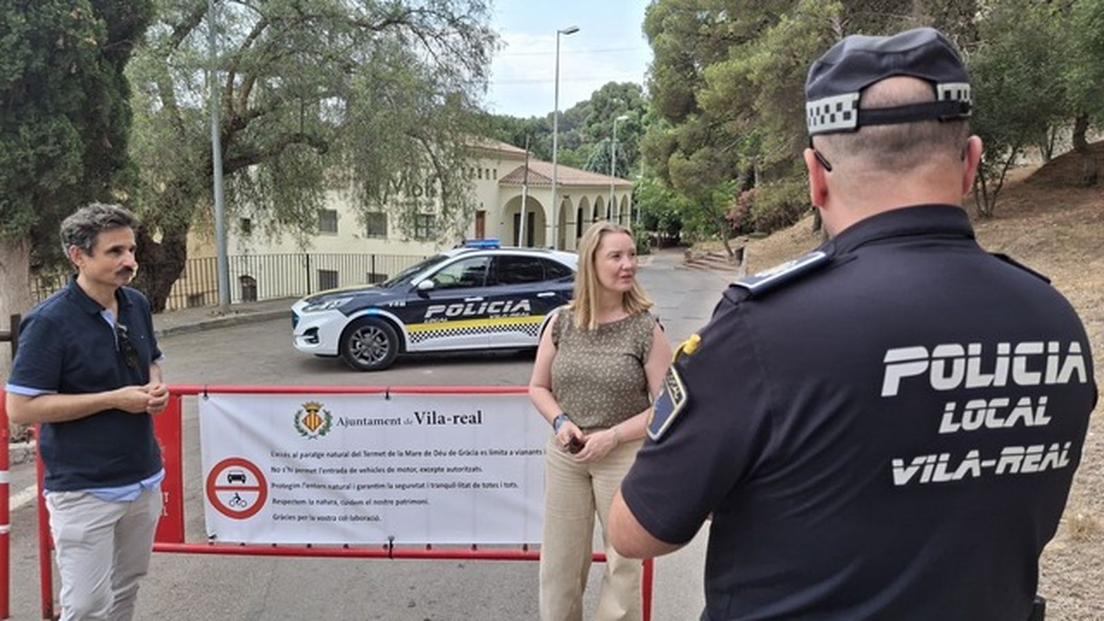 Els regidors Toni Marín i Maria Fajardo i un agent de la Policia Local al costat de la tanca col·locada per a impedir l'accés dels vehicles