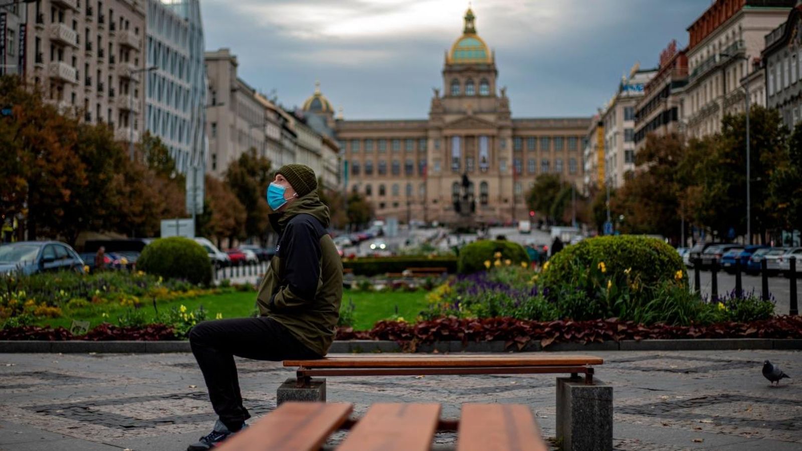 Un home està assegut en un banc en la Plaça Wenceslao, amb el Museu Nacional tancat al fons, a Praga, la República Txeca