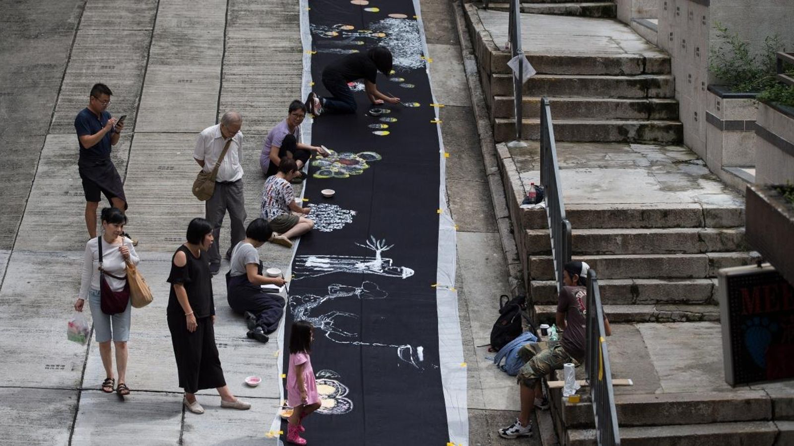 Artistes locals pinten en una tela sobre el tema de les protestes