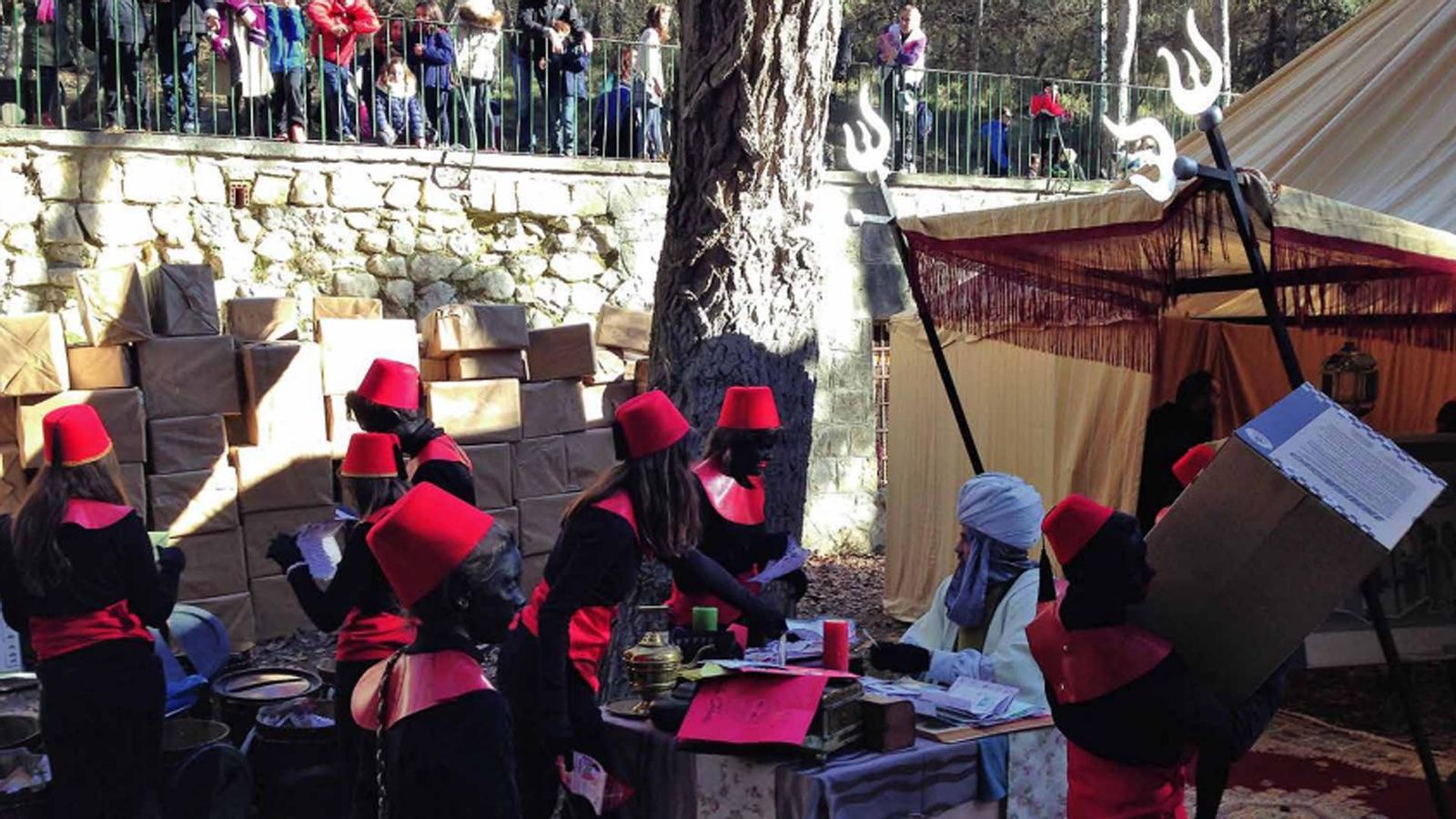 Els patges i els Reis descansen al campament reial en haimes i treballen a destall embolicant regals