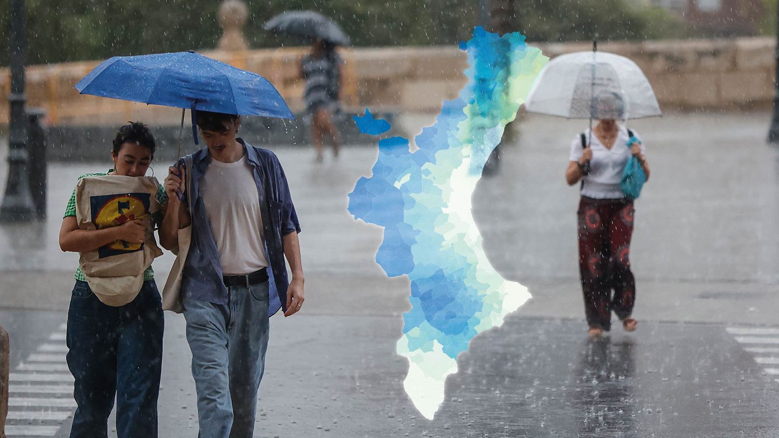 Varies persones amb paraigua durant un episodi de pluges en una imatge d'arxiu