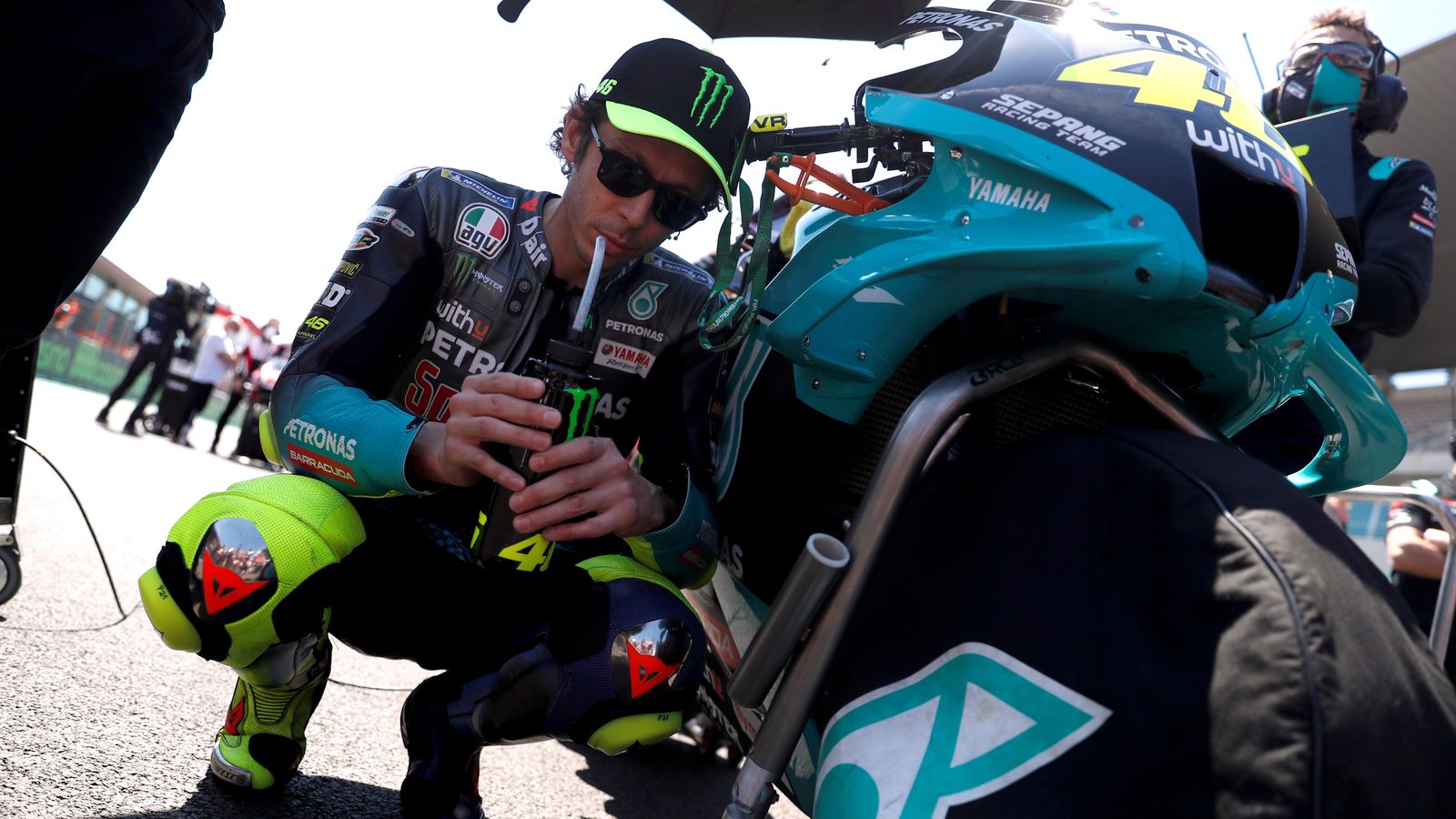 Rossi es refugia de la calor a l'ombra de la seua moto en el Gran Premi de Portugal