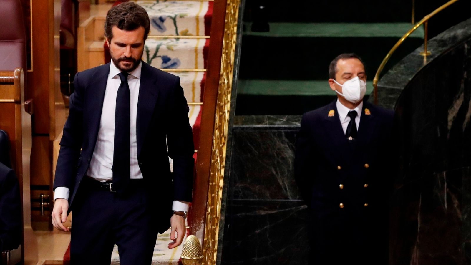 El líder del PP, Pablo Casado, passa pel costat d'un funcionari del Congrés protegit amb una mascareta