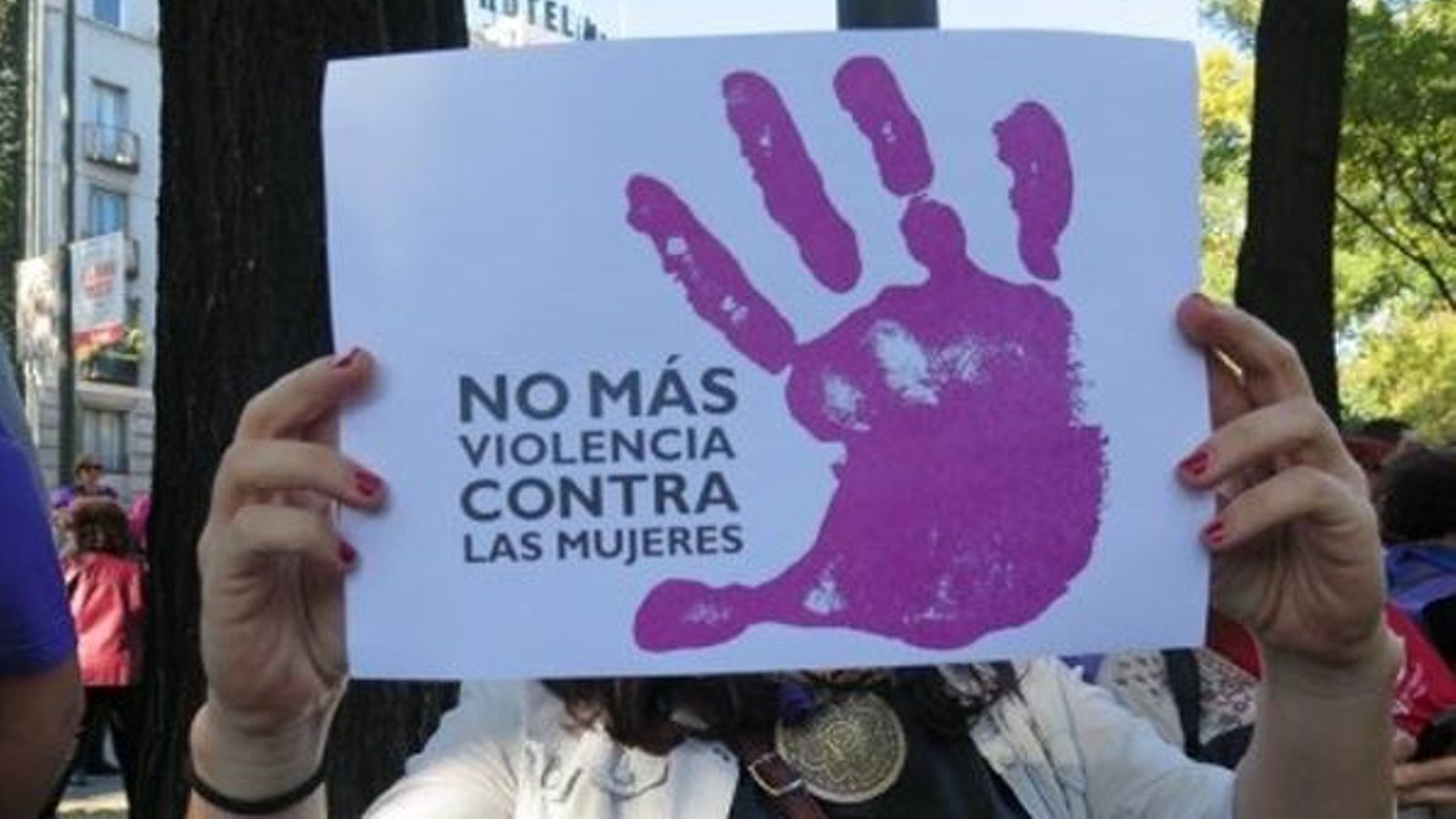 Una dona sosté un cartell en una protesta