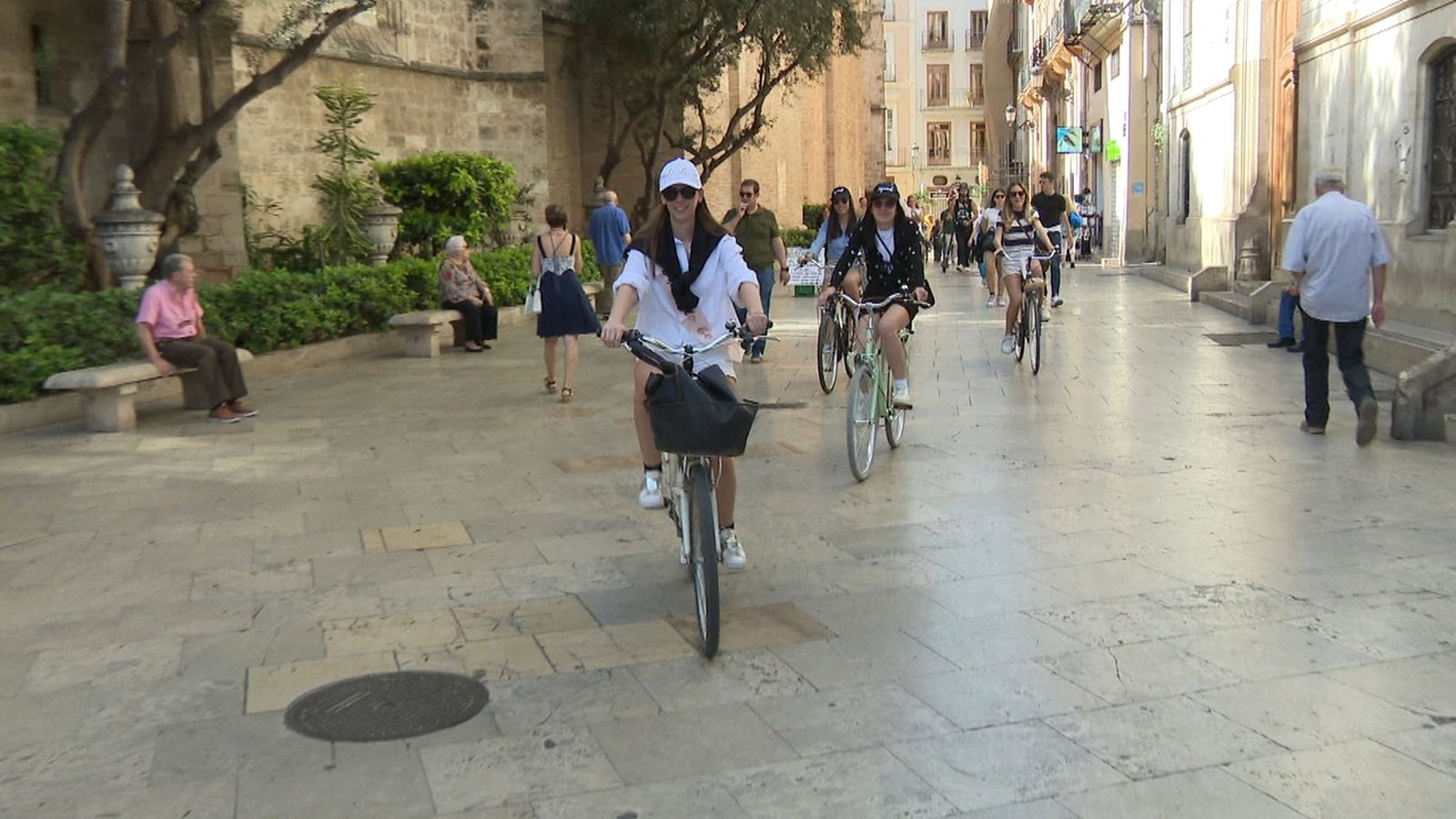 Turistes en bicicleta per la plaça de la Mare de Déu de València