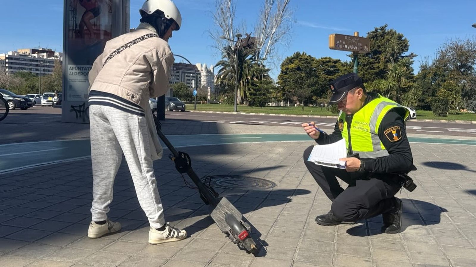 Un Policia Local de València revisa un patinet en un dels controls desplegats per la ciutat