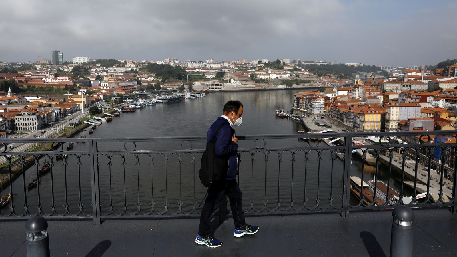 Un home creua un pont a Porto