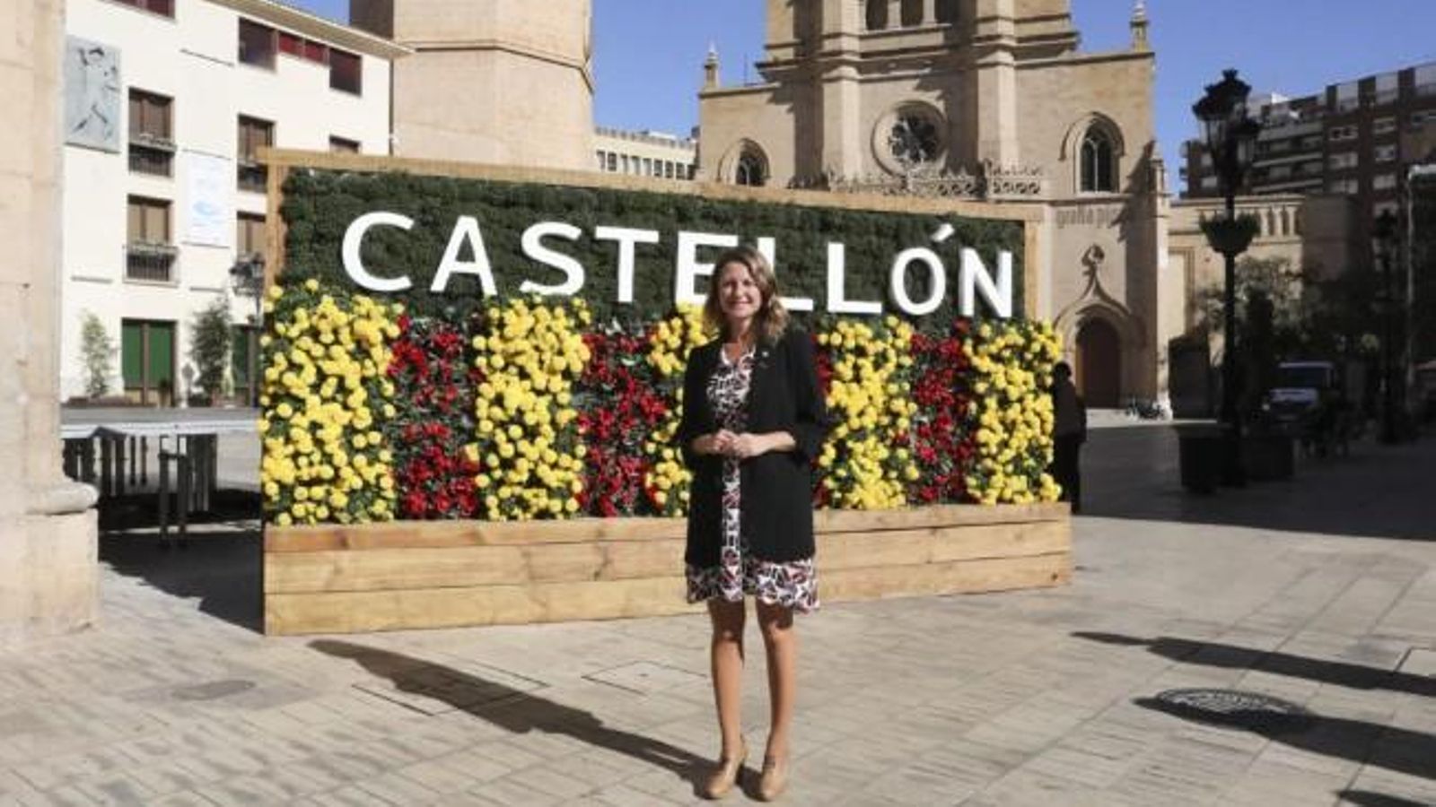 L'alcaldessa davant d'un tapís floral en la plaça Major on, d'una banda, es llig Castellón (imatge) i per l'altre costat, Castelló, respectant la doble cooficialitat