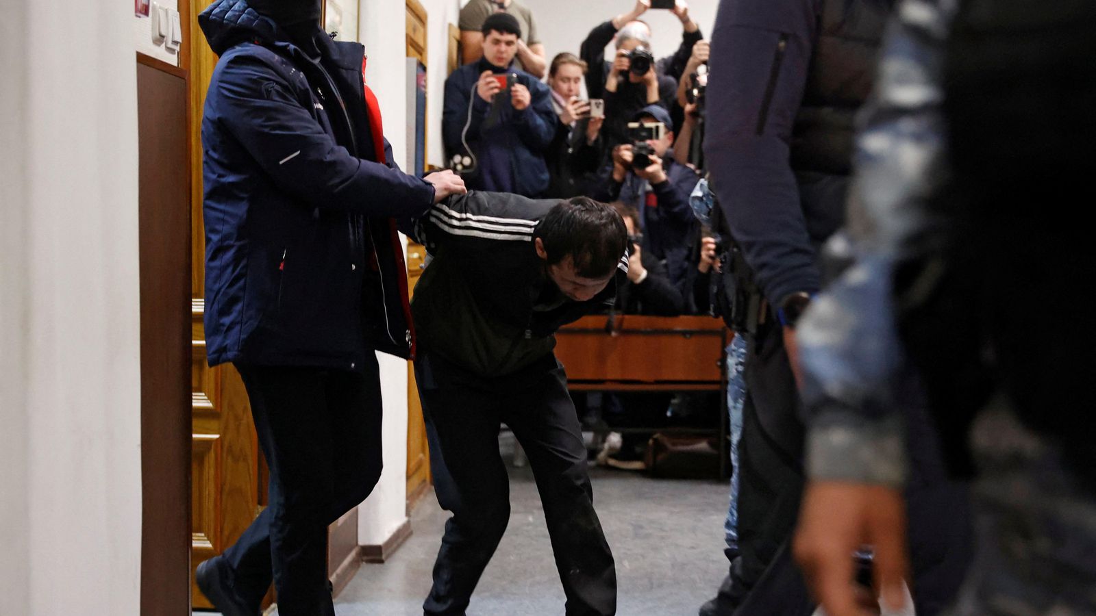 Les forces policials russes escorten un dels sospitosos davant del tribunal de justícia